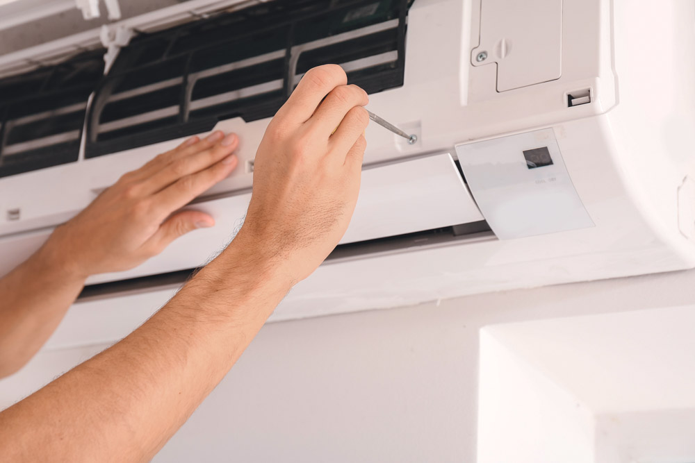 A technician inspecting an indoor air conditioning unit