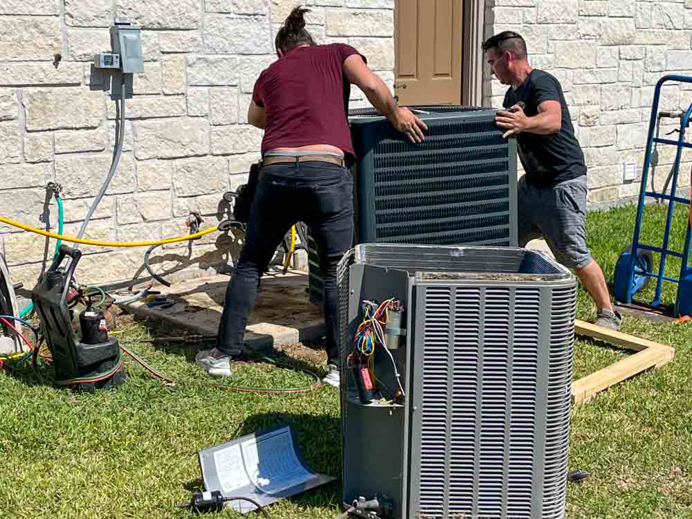 J. Tullos Services technicians setting a new outdoor condenser unit