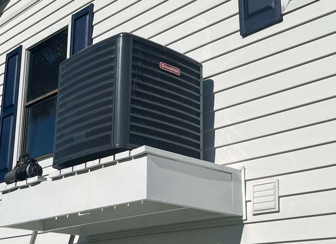 New outdoor AC condenser installed beside a home by J. Tullos Services